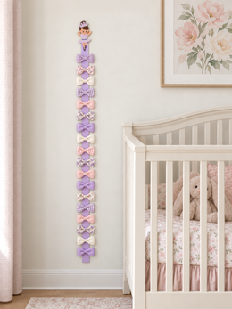 Full-length wooden ballerina hair bow holder with 18 bows beside a nursery crib