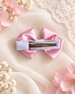 Little Petal, petite 2-inch blush pink satin hair bow held in hand to show size