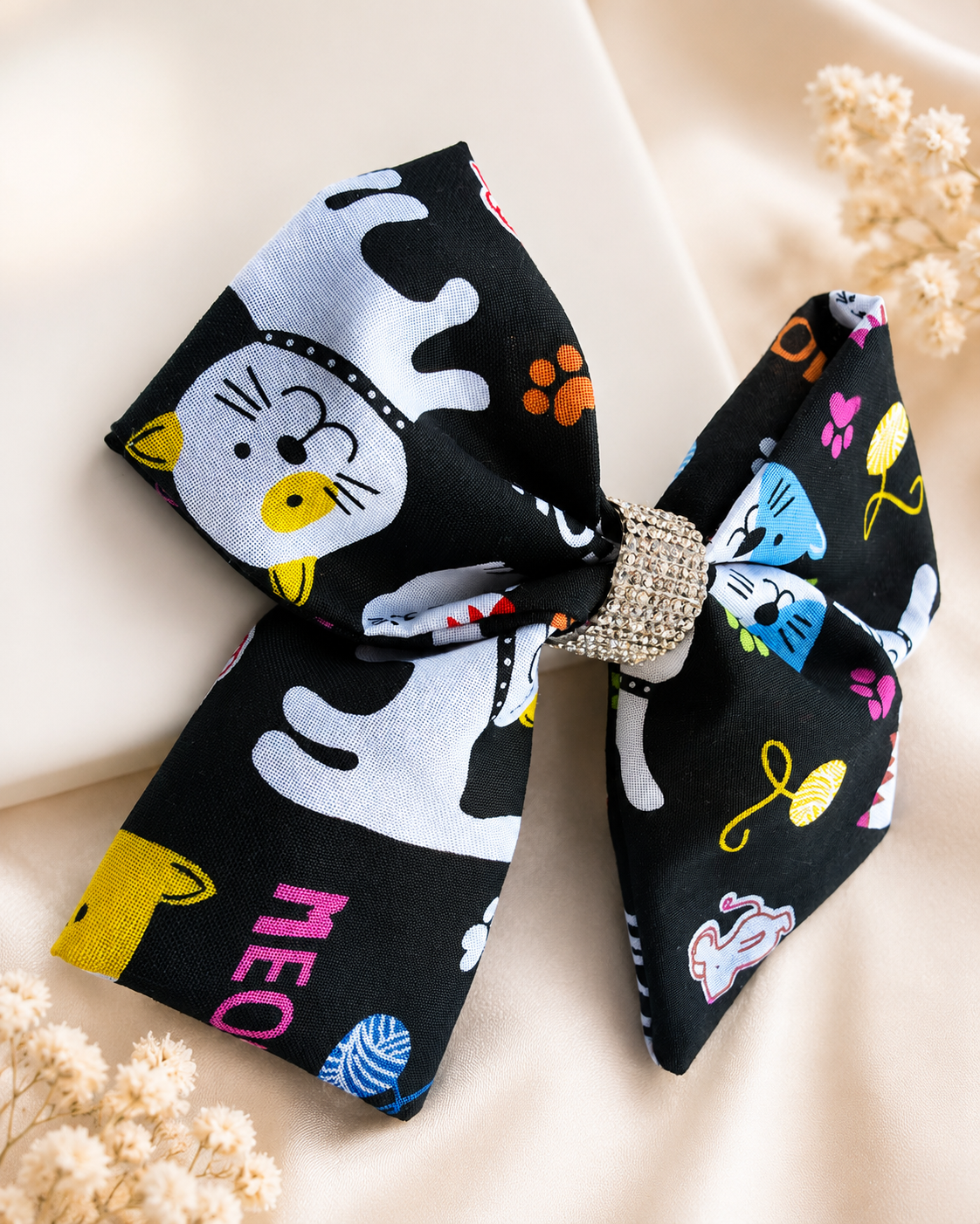 Girls black cat statement hair bow with colorful paw print details