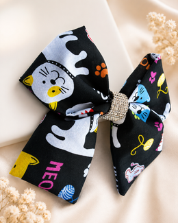 Girls black cat statement hair bow with colorful paw print details