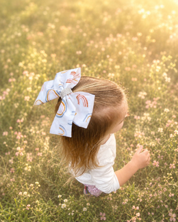 Back of Golden Skies Bow, approximately 6-inch ivory rainbow hair bow showing the attached non-slip alligator clip