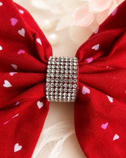 Close-up of Love Letter Bow, approximately 6-inch red heart-print hair bow showing fabric and center detail