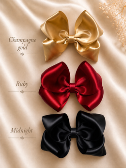 Styled flat lay of The Classic Everly Bow, approximately 5.5-inch satin hair bow