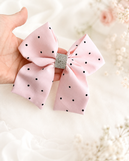 Styled flat lay of Blushing Dottie Bow, 6-inch blush pink polka-dot hair bow