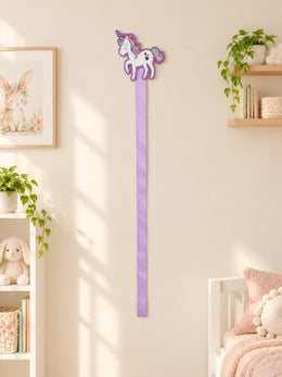 Rainbow unicorn bow holder on a cream nursery wall