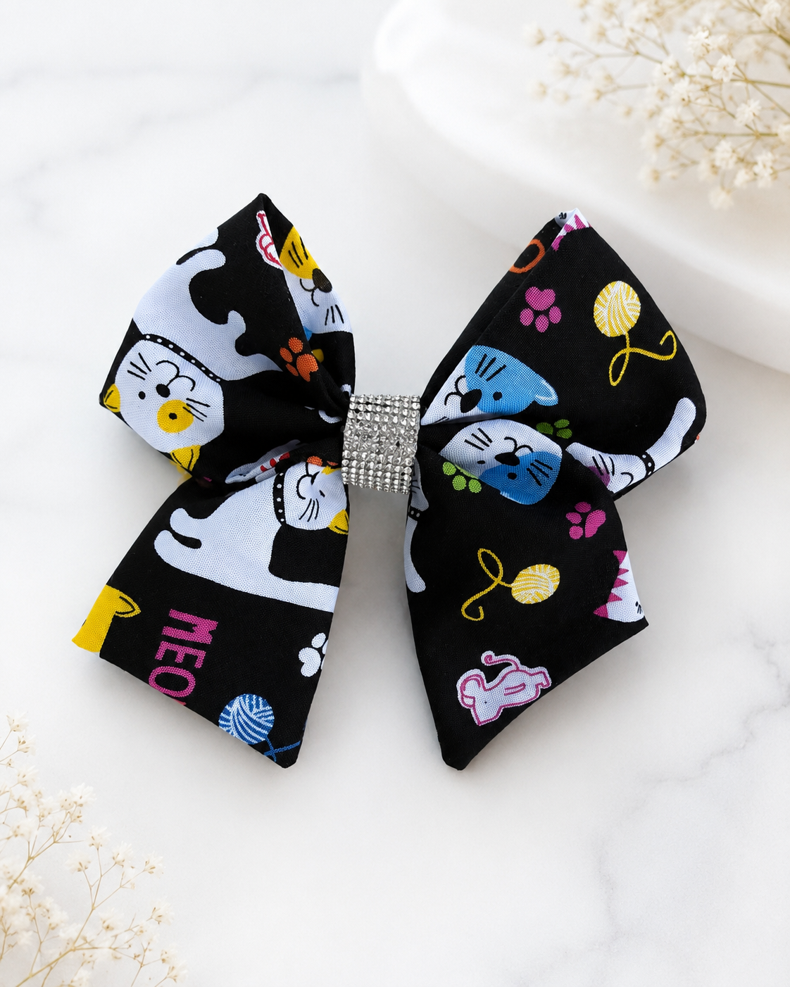 Black cat print 6 inch hair bow with colorful paw prints and rhinestone center