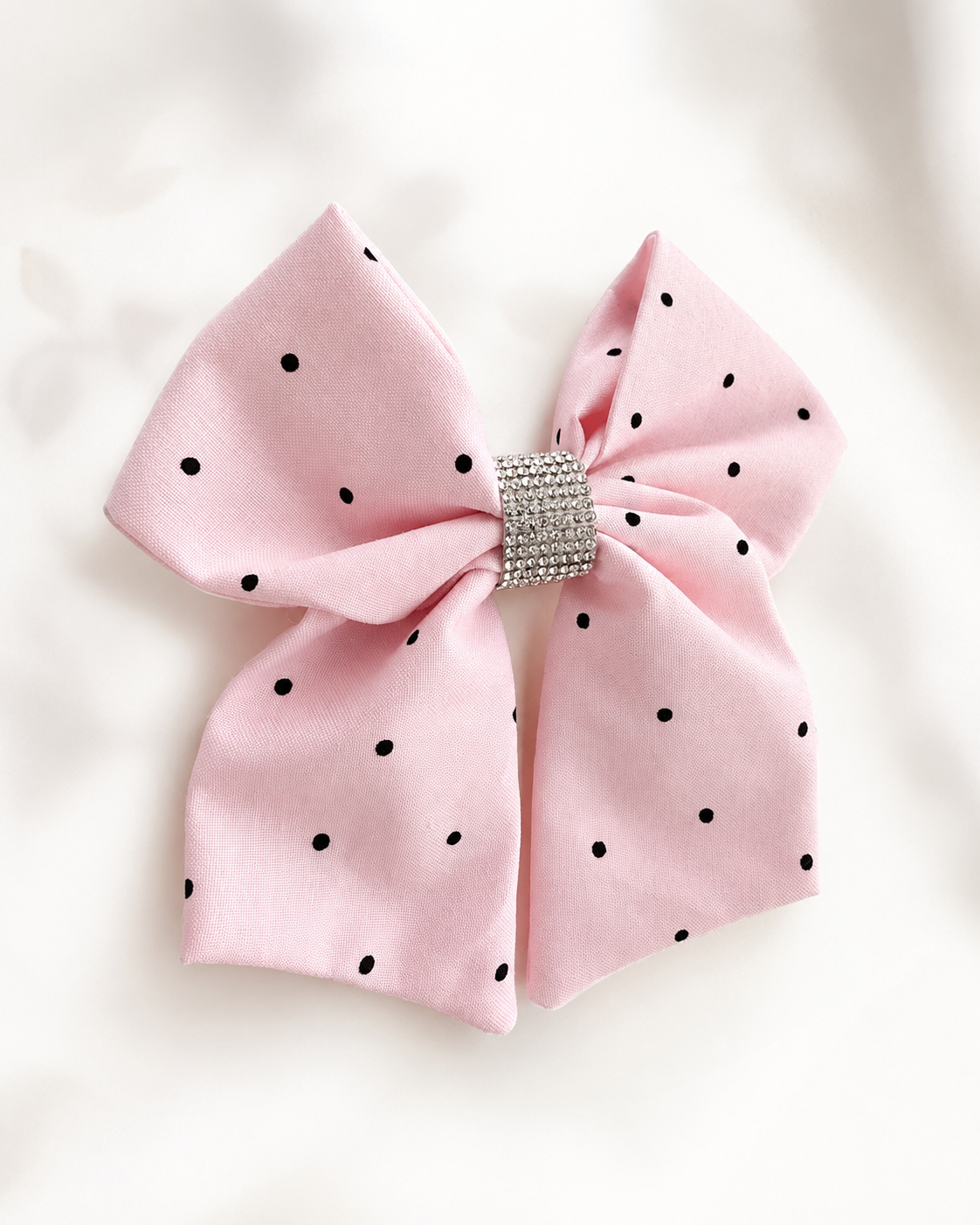Blushing Dottie Bow, 6-inch blush pink polka-dot hair bow held in hand to show size