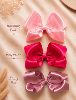 Close-up of The Classic Everly Bow, approximately 5.5-inch satin hair bow showing fabric and center detail