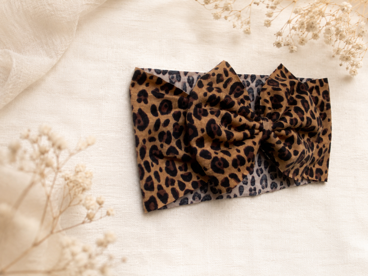 Close-up of Little in Leopard, leopard bow headband showing fabric and center detail