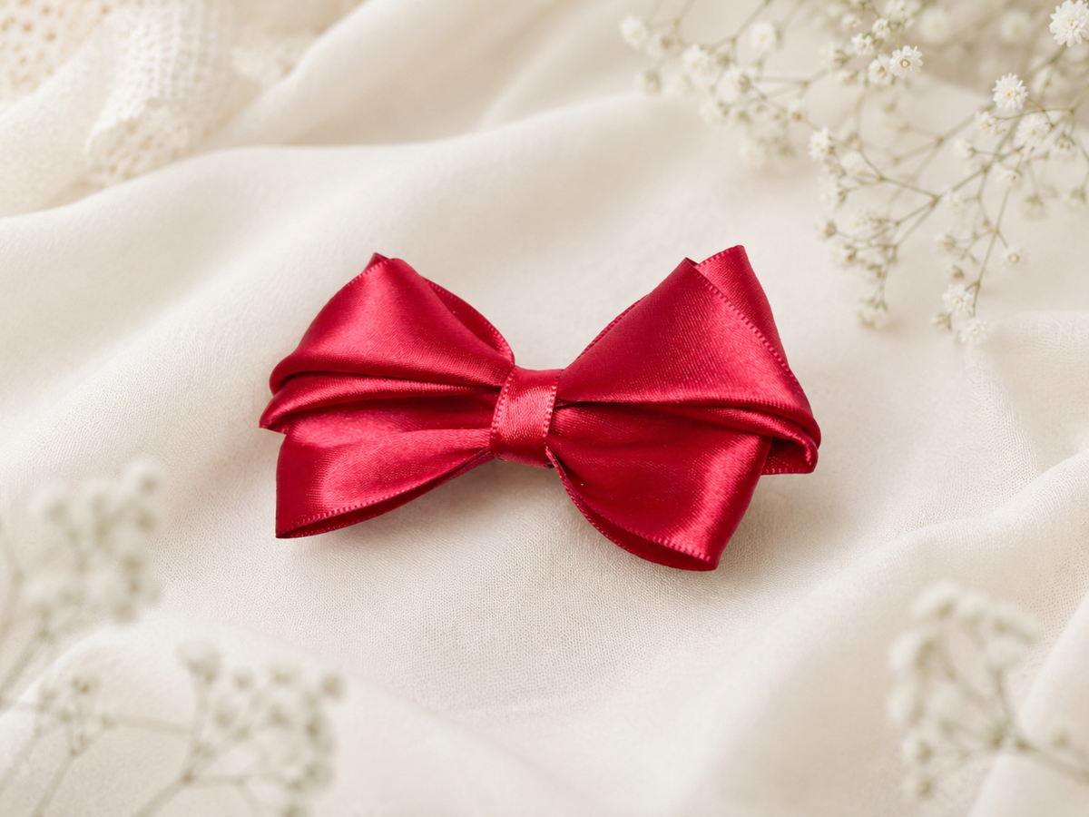 Close-up of Merry Little Magic, 3.5-inch red satin hair bow showing fabric and center detail