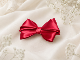Close-up of Merry Little Magic, 3.5-inch red satin hair bow showing fabric and center detail