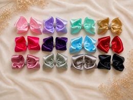 Close-up of The Rhinestone Everly Bow, approximately 5.5-inch satin hair bow showing fabric and center detail