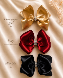 Styled flat lay of The Rhinestone Everly Bow, approximately 5.5-inch satin hair bow