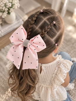 Blushing Dottie Bow, 6-inch blush pink polka-dot hair bow worn in a girl's hairstyle to show scale