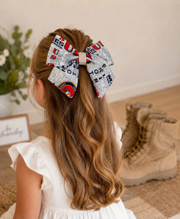 Semper Fi Darling Bow, approximately 6-inch Marine Corps-inspired hair bow worn in a girl's hairstyle to show scale
