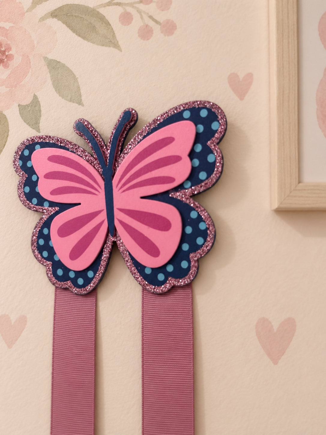 Close-up of butterfly bow holder with two pink ribbons