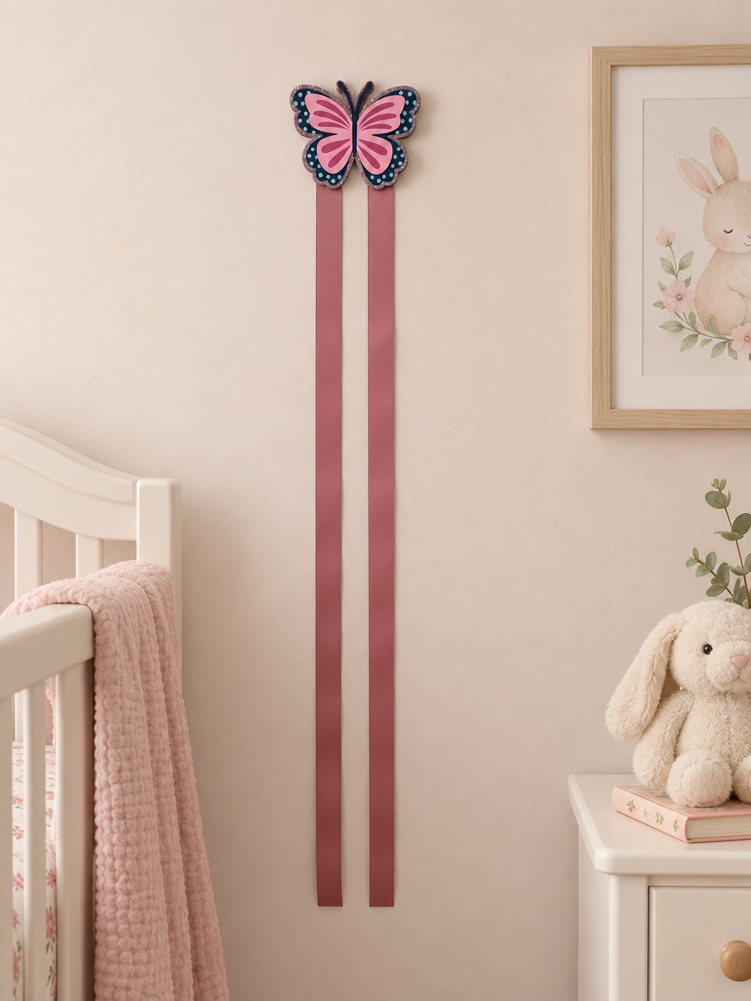 Two-ribbon butterfly bow holder in a soft nursery setting