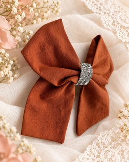 Burnt orange rhinestone boutique hair bow angled view