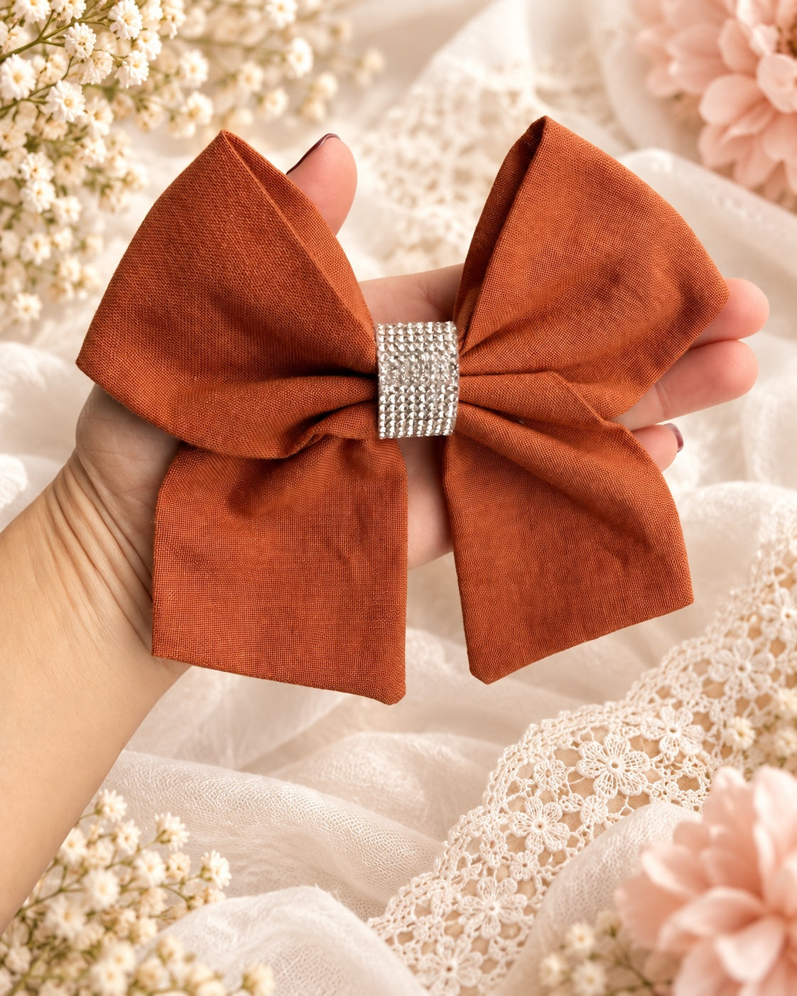 5.5 inch burnt orange rhinestone girls hair bow shown in hand