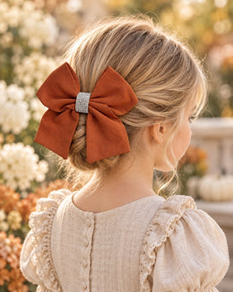 Girl wearing burnt orange rhinestone 5.5 inch hair bow with elegant updo
