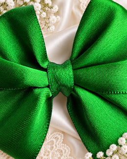 Close up of emerald green satin hair bow fabric and center