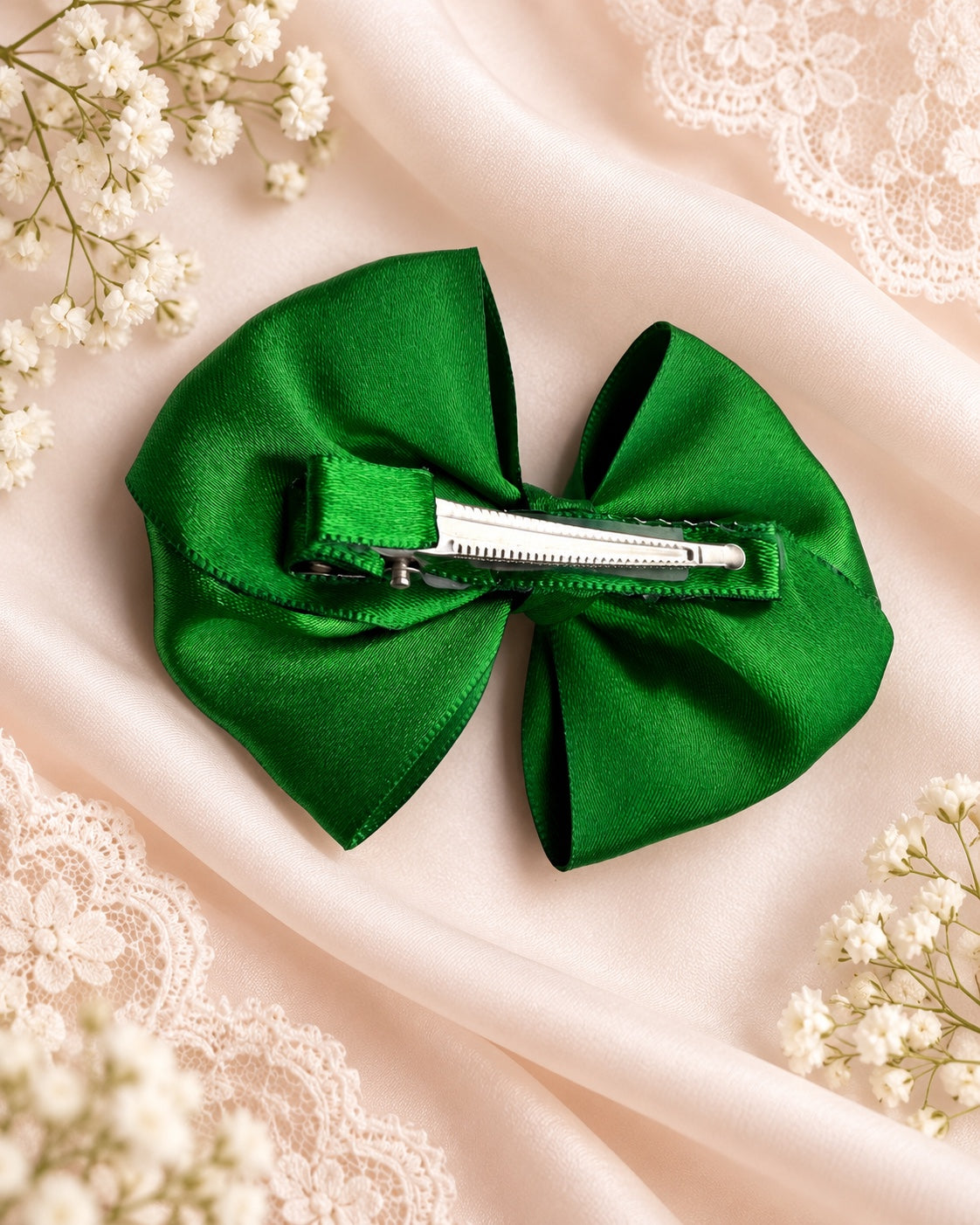 Back of emerald green satin hair bow with alligator clip