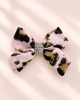 Angled view of 3 inch Gilded Leopard mini hair bow with blush pink black gold animal print and rhinestone center