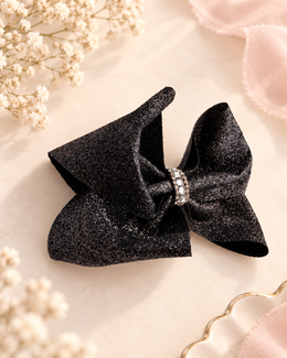 Black glitter boutique hair bow with crystal rhinestone center angled view