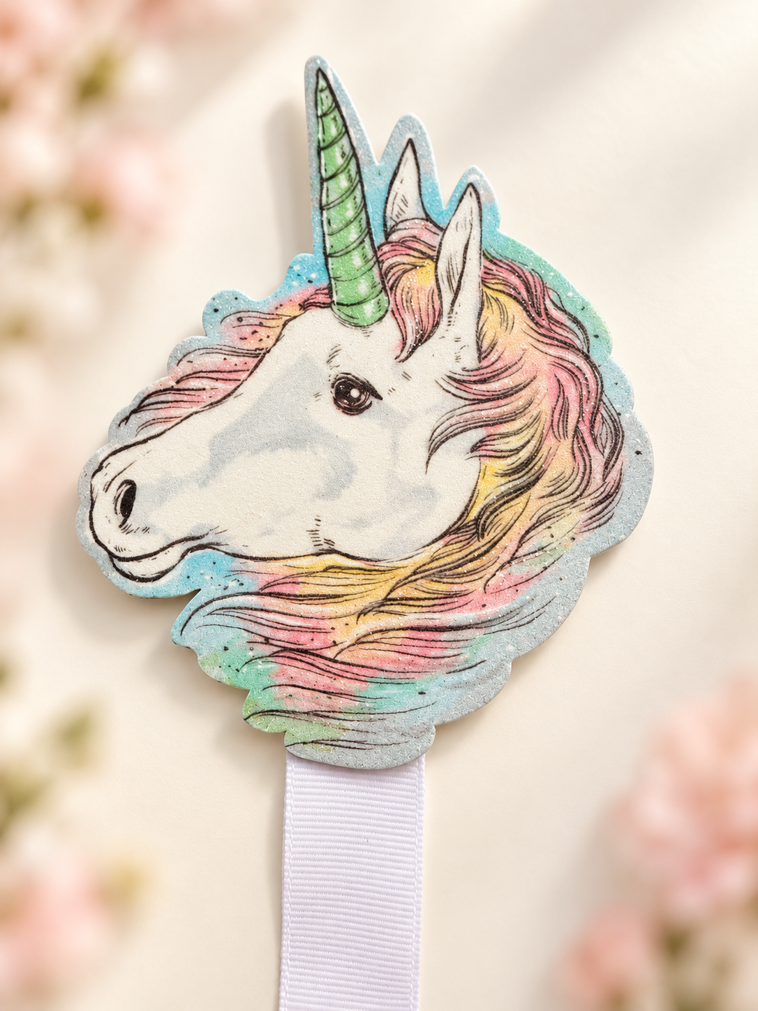 Close-up of the pastel unicorn head topper with mint horn and pink, yellow, and mint mane
